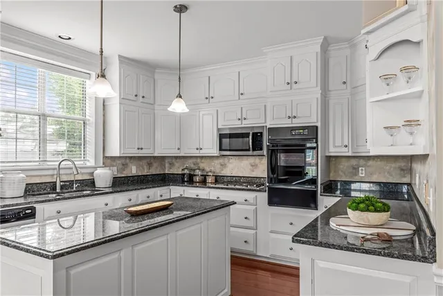 a bathroom with a granite countertop sink a potted plant and a shower
