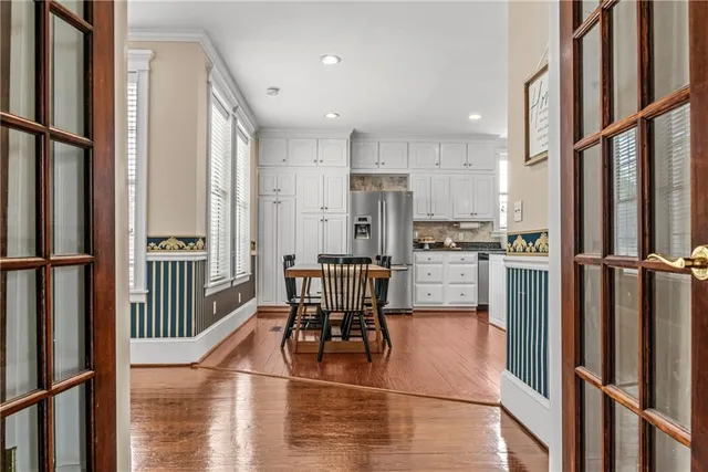 an empty room with wooden floor and windows