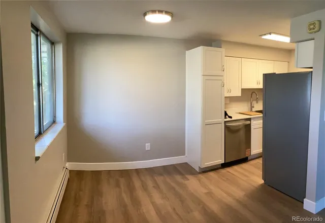 a view of kitchen with stainless steel appliances wooden floor and a window