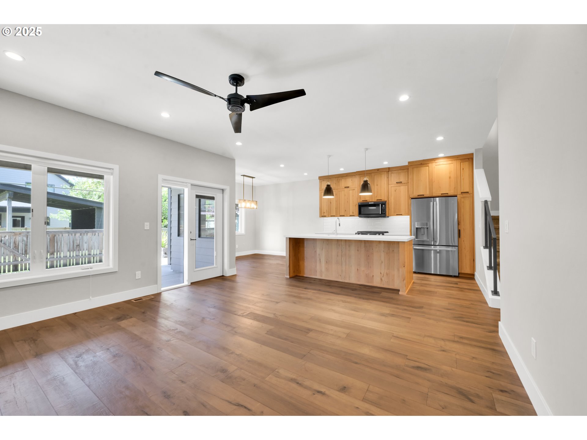 1915 Elkhorn Drive Eugene, OR 97408 - Photo 8 of 28 a view of an empty room with wooden floor and a kitchen
