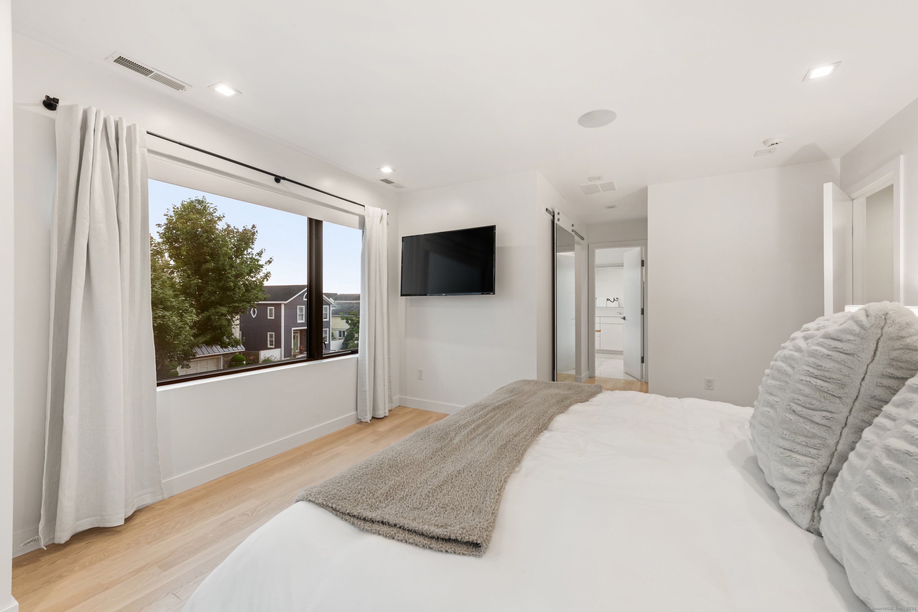 200 Hillspoint Road Westport, CT 06880 - Photo 27 of 37 a bedroom with a large bed and a flat screen tv
