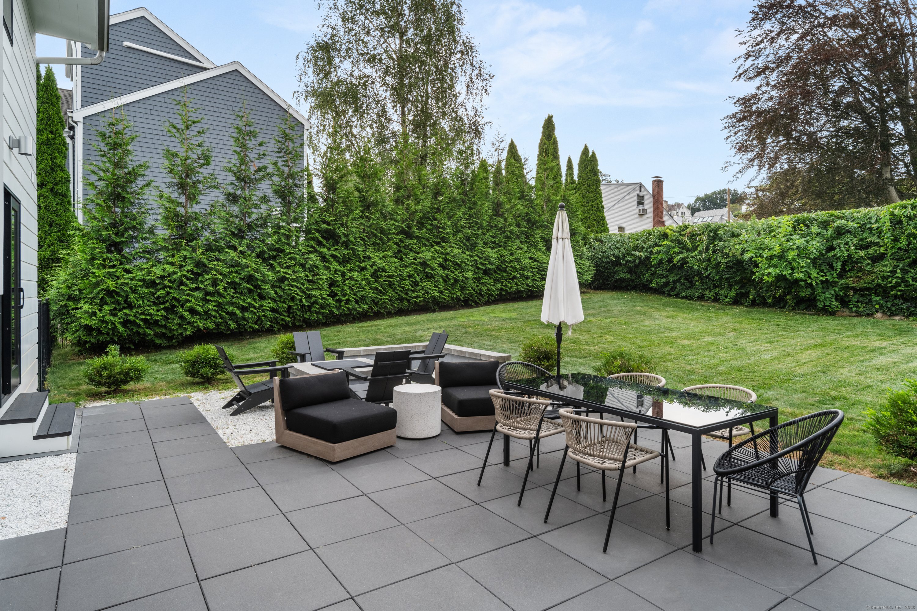 200 Hillspoint Road Westport, CT 06880 - Photo 3 of 37 a view of a patio with table and chairs potted plants and a large tree