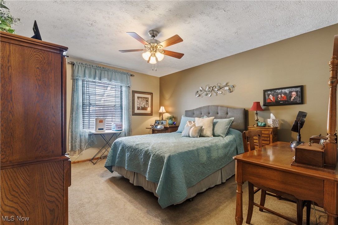 14816 Denman Road Wakeman, OH 44889 - Photo 11 of 41 Bedroom with ceiling fan, a textured ceiling, and light colored carpet