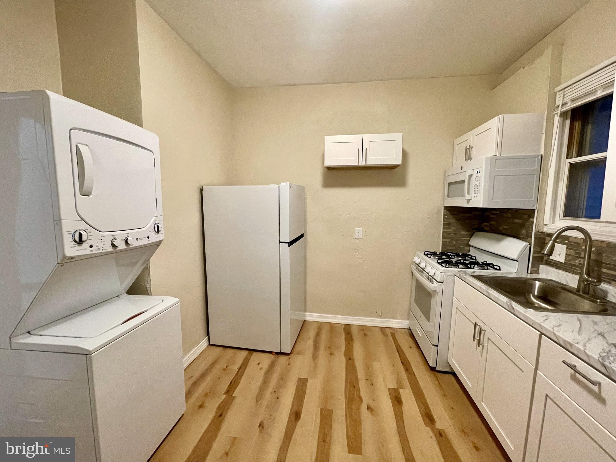 3151 G Street, Unit A Philadelphia, PA 19134 - Photo 5 of 6 a kitchen with a refrigerator and a stove