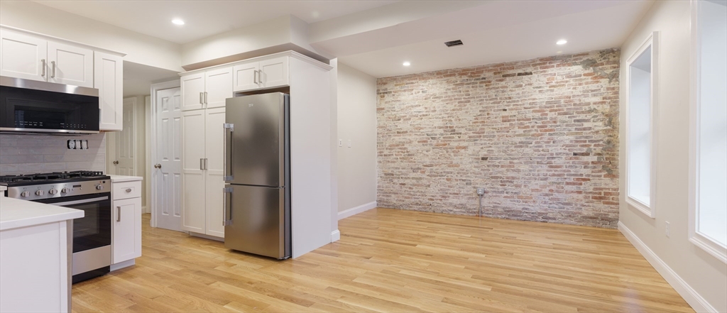 a kitchen with stainless steel appliances a refrigerator and a stove top oven
