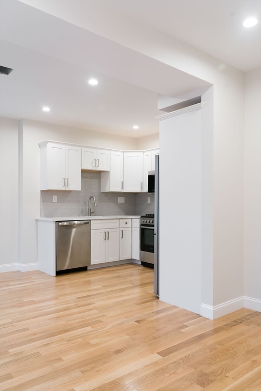 217 West 9th Street, Unit 2 Boston, MA 02127 - Photo 4 of 14 a large kitchen with stainless steel appliances granite countertop a stove a sink and a refrigerator