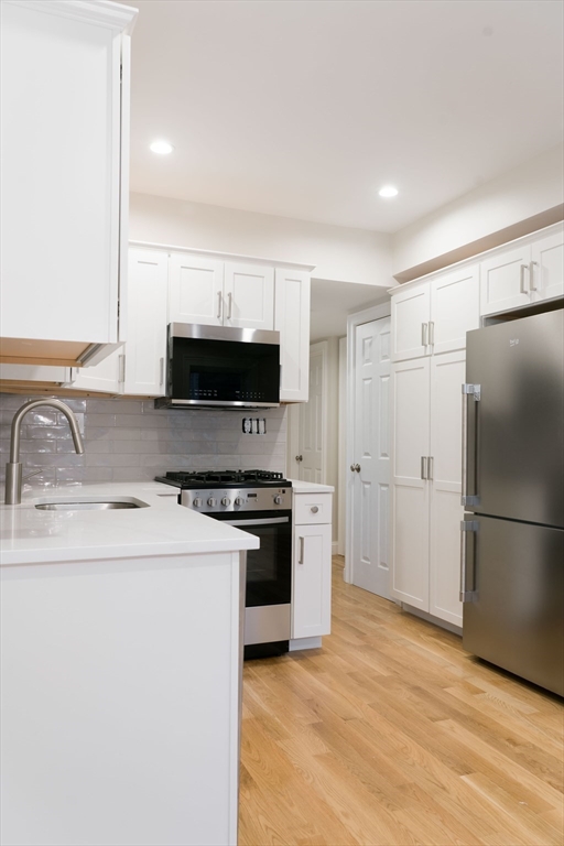 217 West 9th Street, Unit 2 Boston, MA 02127 - Photo 6 of 14 a kitchen with stainless steel appliances a refrigerator stove and sink