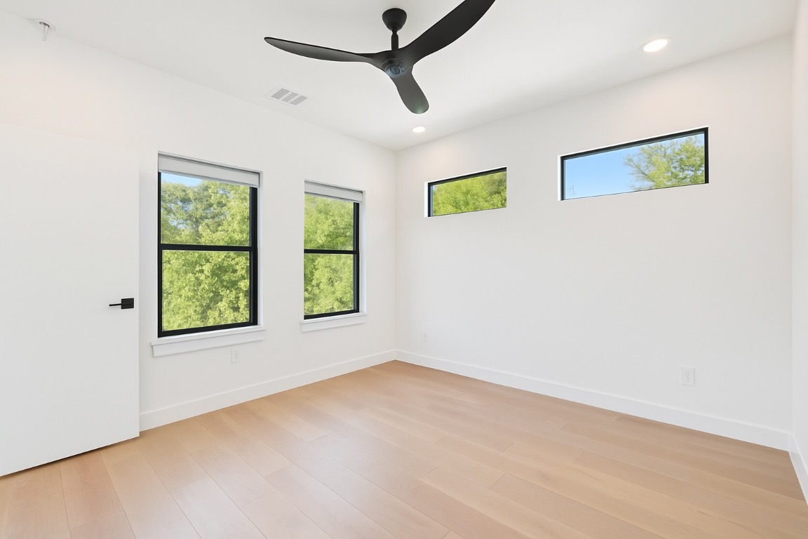 2916 East 13th Street, Unit 2 Austin, TX 78702 - Photo 12 of 35 Spare room featuring healthy amount of natural light, light wood-style floors, recessed lighting, and ceiling fan