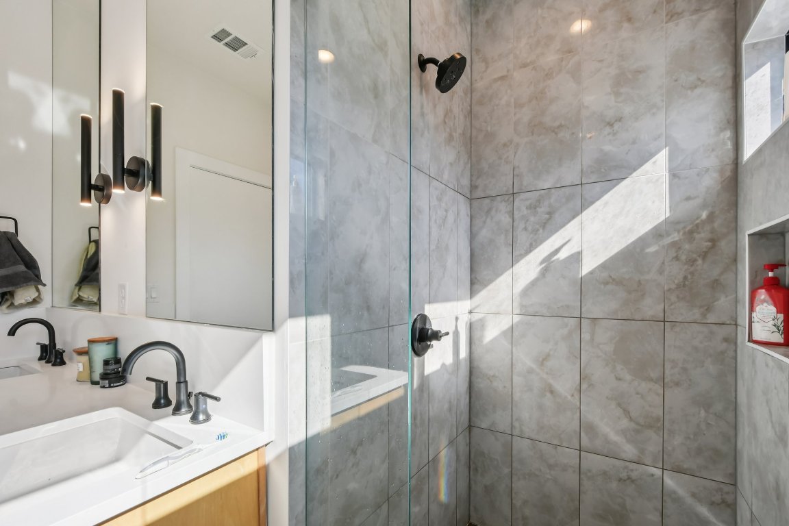 2916 East 13th Street, Unit 2 Austin, TX 78702 - Photo 16 of 35 Bathroom featuring a walk in shower and double vanity