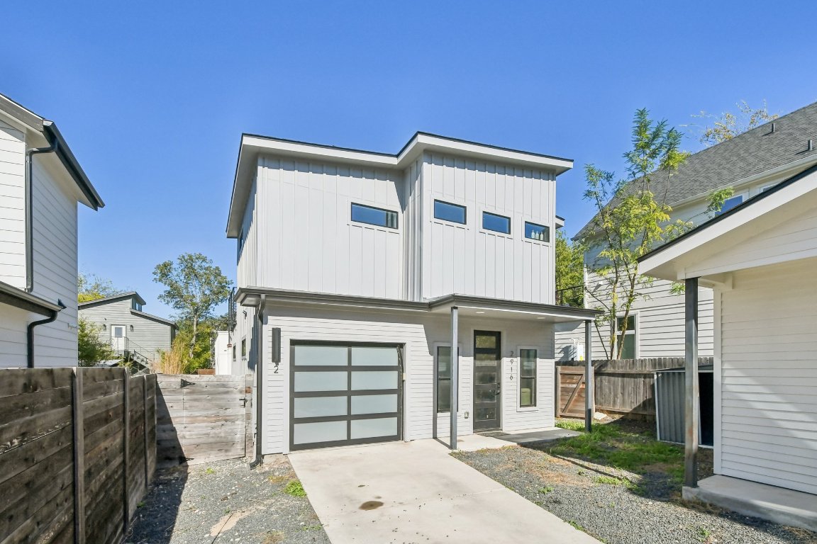 2916 East 13th Street, Unit 2 Austin, TX 78702 - Photo 2 of 35 View of front of home with board and batten siding, driveway, and an attached garage