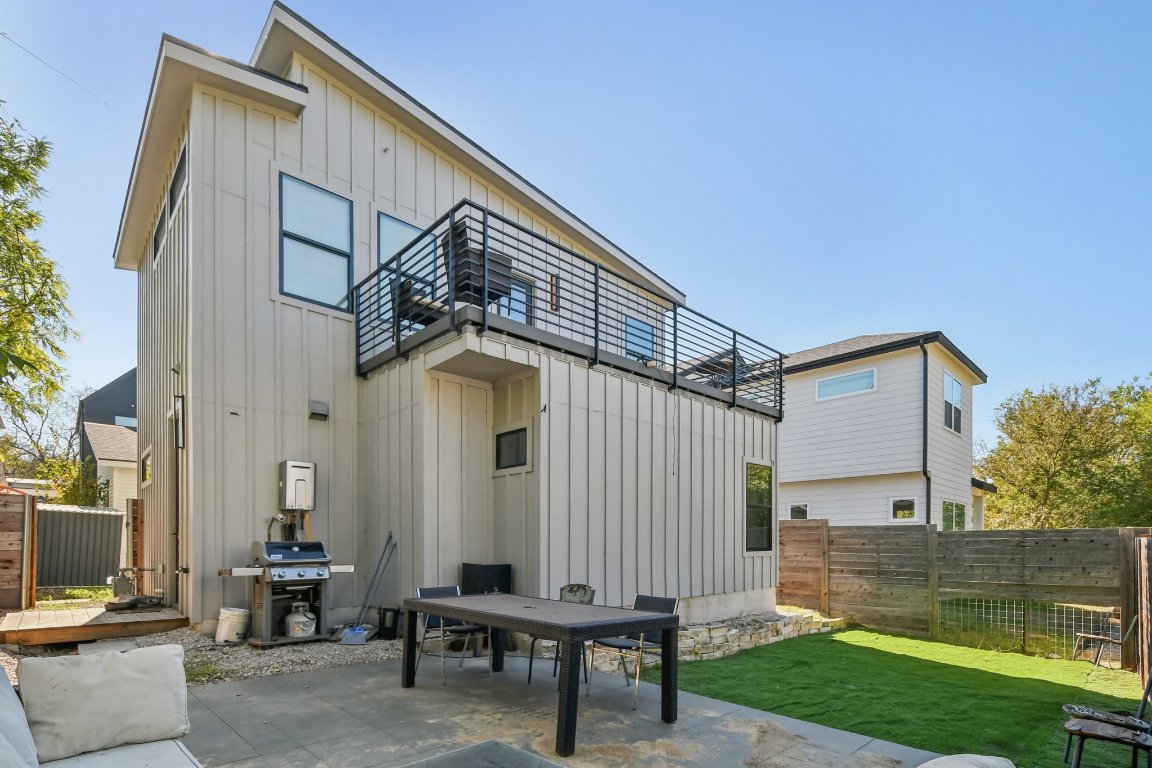 2916 East 13th Street, Unit 2 Austin, TX 78702 - Photo 32 of 35 Rear view of house with board and batten siding, a fenced backyard, and a patio area