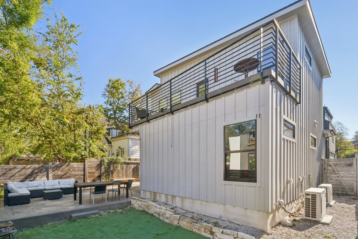 2916 East 13th Street, Unit 2 Austin, TX 78702 - Photo 33 of 35 View of side of home with an outdoor hangout area, a fenced backyard, and board and batten siding
