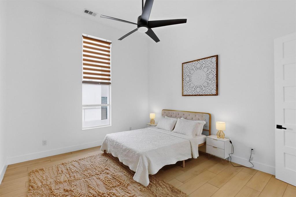 3946 North Cresthaven Road Dallas, TX 75209 - Photo 22 of 38 Room featuring a vaulted ceiling with a modern ceiling fan, wood-finish flooring, and a tall window with horizontal blinds