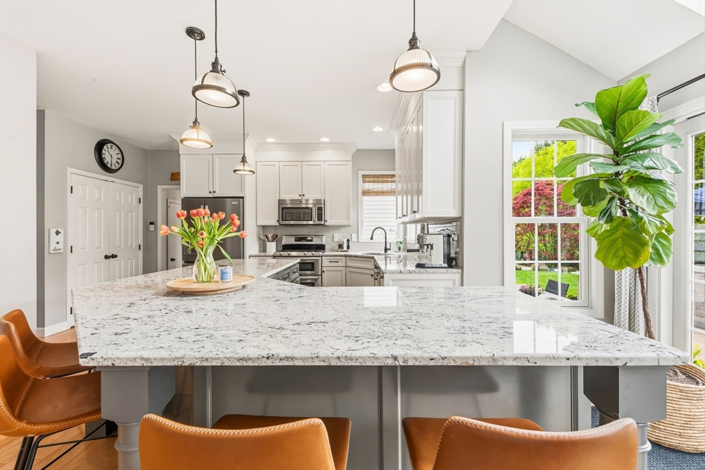6 Hancock Road Franklin, MA 02038 - Photo 12 of 32 a kitchen with granite countertop kitchen island stainless steel appliances a sink and a chandelier
