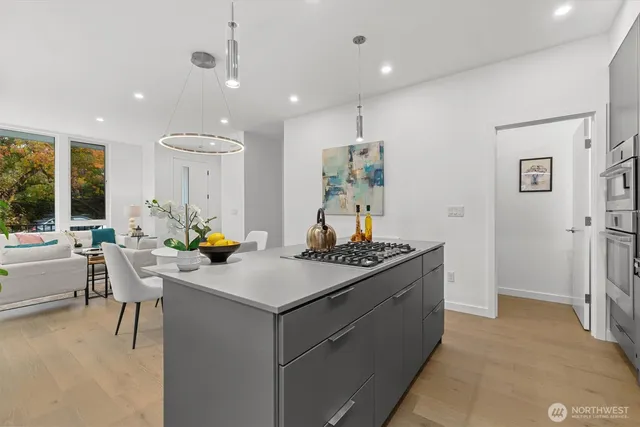 a kitchen with a stove a refrigerator and a dining table with wooden floor