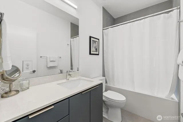 a bathroom with a sink a toilet and shower curtain