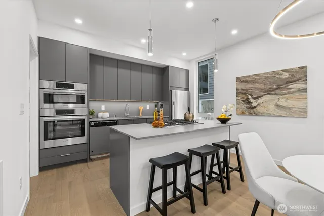 a kitchen with kitchen island a stove a table and chairs in it