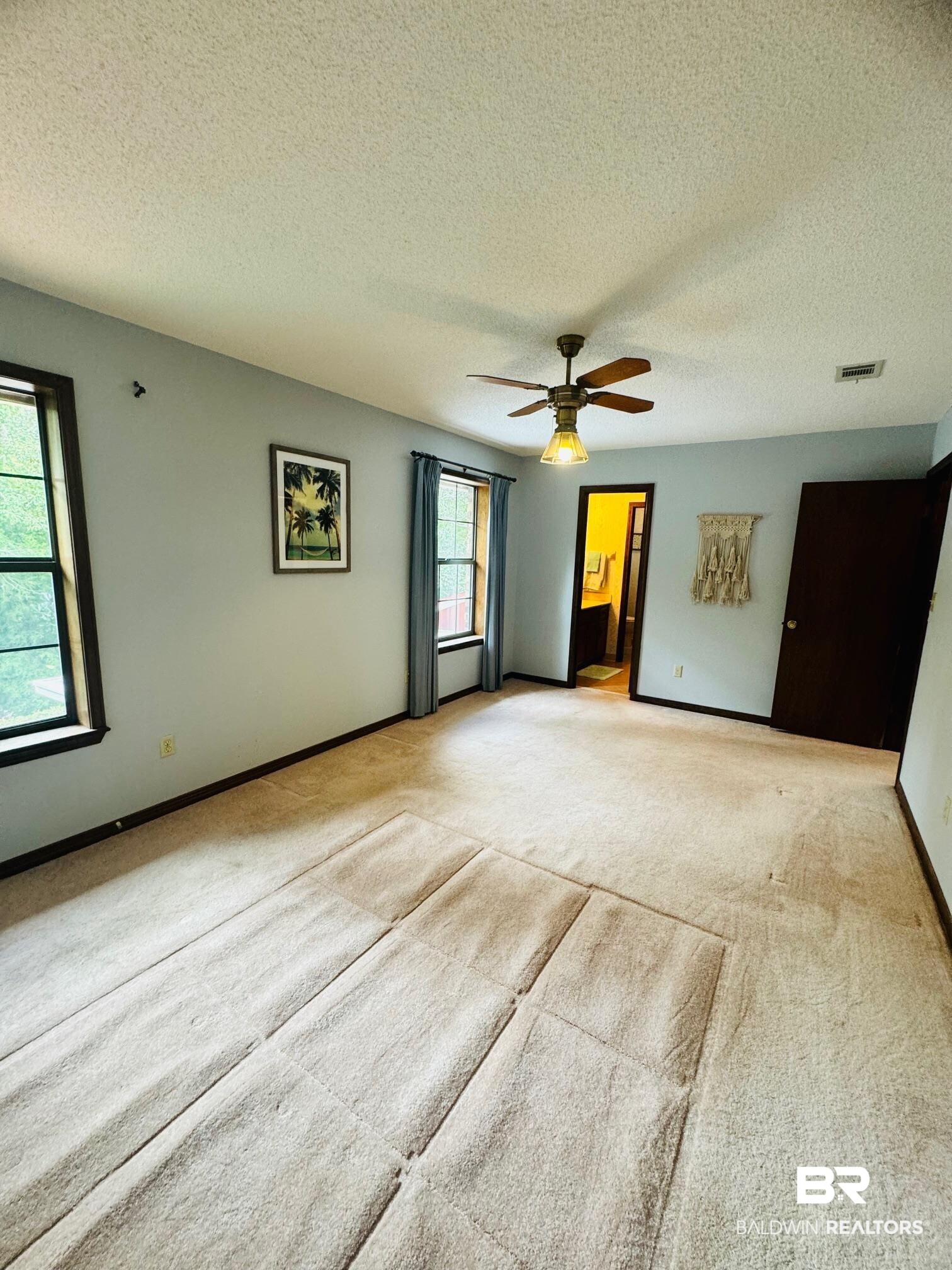 2240 Perdido Circle Lillian, AL 36549 - Photo 15 of 42 Unfurnished room with ceiling fan, light colored carpet, and a textured ceiling