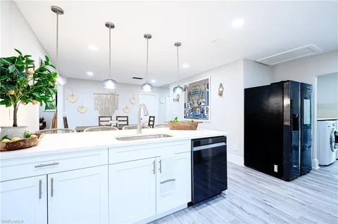 a kitchen with kitchen island white cabinets and stainless steel appliances