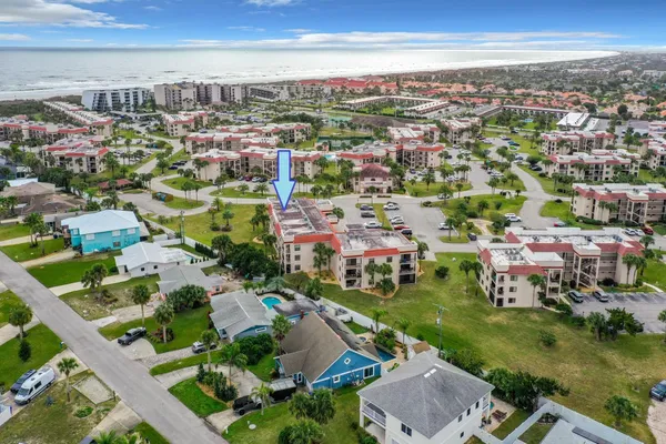 an aerial view of a city with lots of residential buildings ocean and mountain view in back