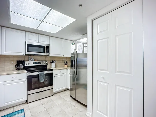 a kitchen with stainless steel appliances granite countertop a refrigerator stove and sink
