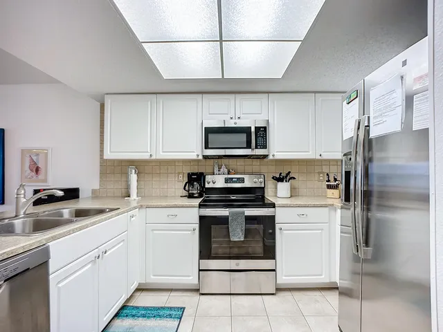 a kitchen with cabinets stainless steel appliances and a sink