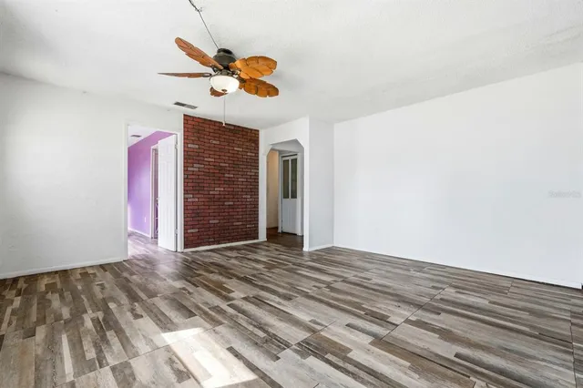 a view of a livingroom with wooden floor and a ceiling fan