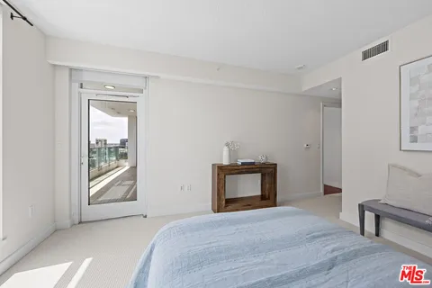 a bedroom with a bed and a potted plant