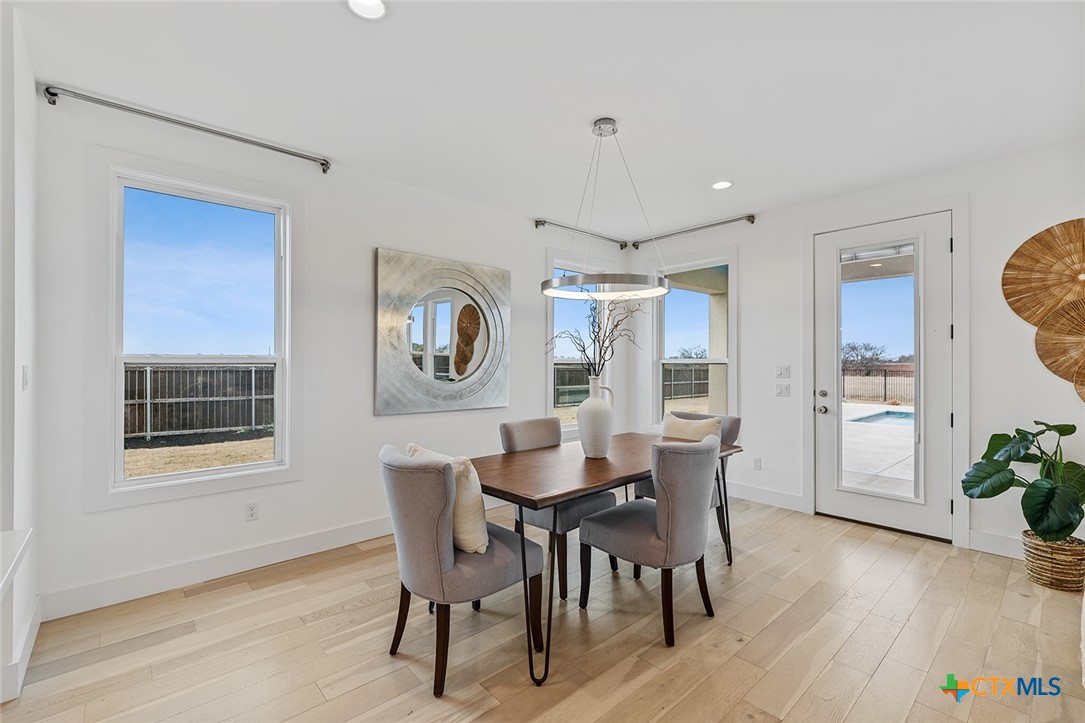 477 Willow Moon Ranch Road Crawford, TX 76638 - Photo 9 of 40 a view of a dining room with furniture and wooden floor