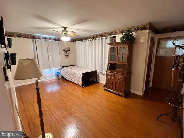 a view of kitchen and empty room with wooden floor