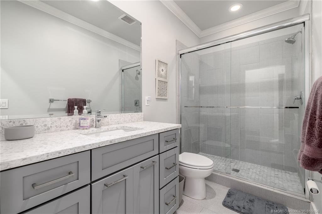 411 Southeast High School Avenue Stuart, FL 34994 - Photo 22 of 37 a bathroom with a granite countertop sink a toilet and shower