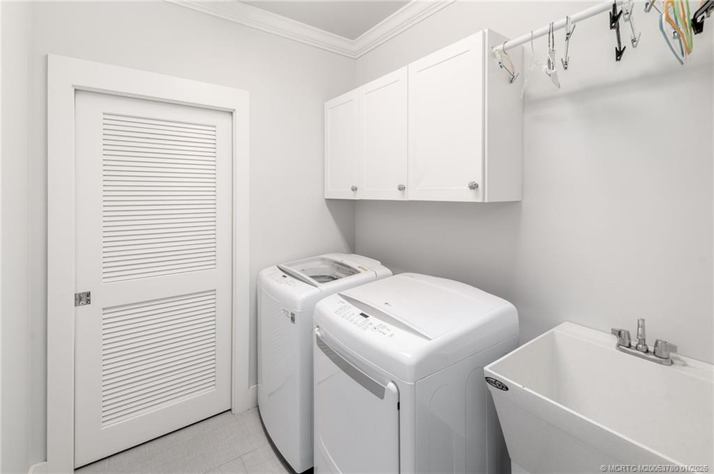 411 Southeast High School Avenue Stuart, FL 34994 - Photo 23 of 37 a view of bathroom with a sink and washer dryer