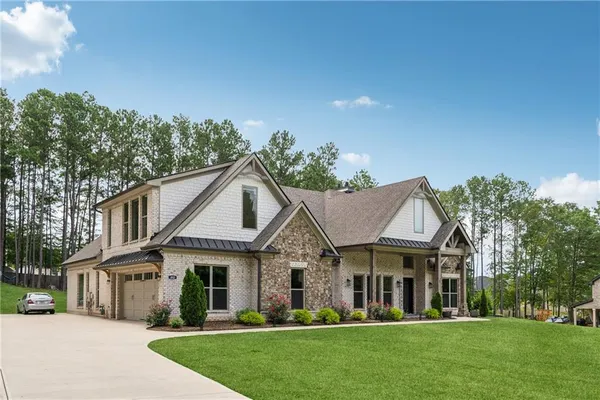 a view of a white house with a big yard and large trees