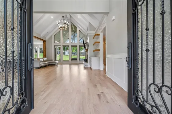 a view of a hallway with wooden floor and a livingroom