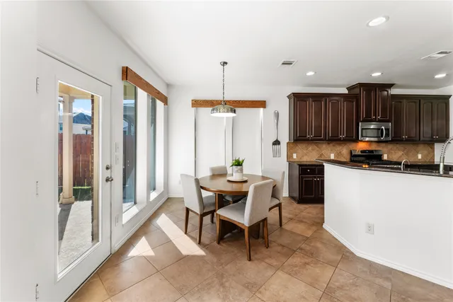 a kitchen with a table chairs refrigerator and cabinets