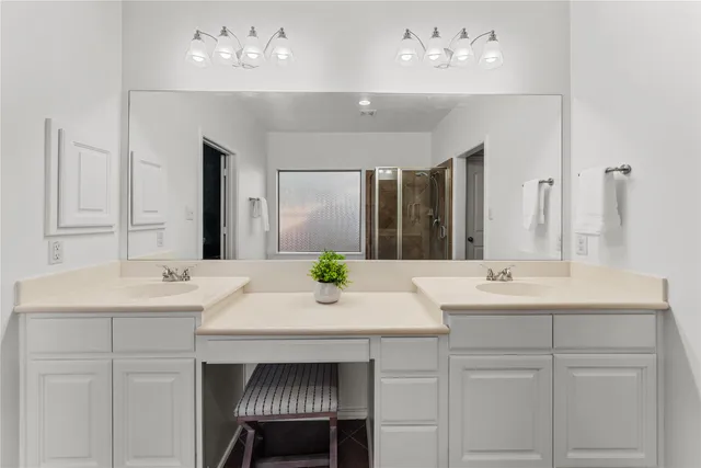 a bathroom with a tub a sink a mirror and a shower