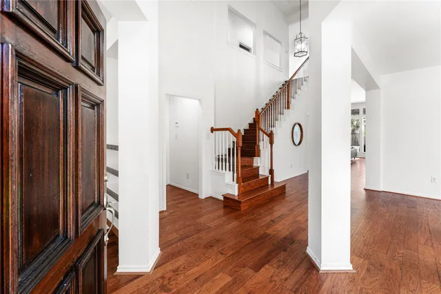 a view of a hallway with wooden floor and staircase