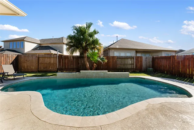 a view of a house with a swimming pool and a yard