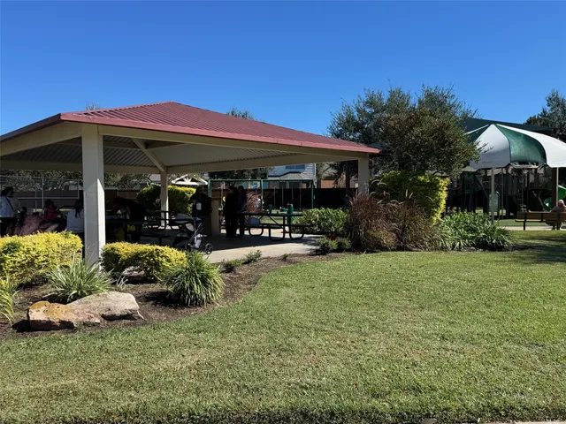 a view of a patio with table and chairs with plants and palm trees