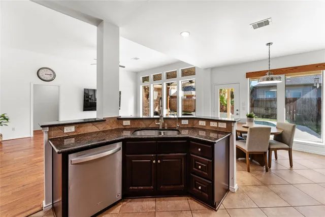 a kitchen with a sink and chairs