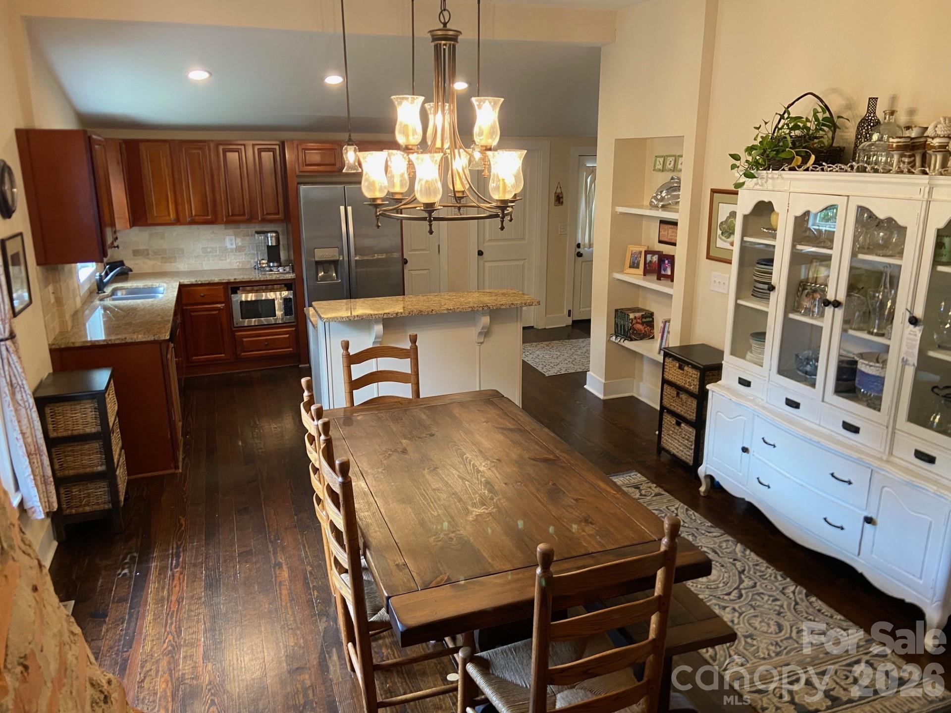 201 Main Street Matthews, NC 28105 - Photo 3 of 16 a kitchen with stainless steel appliances wooden floor dining table and chairs