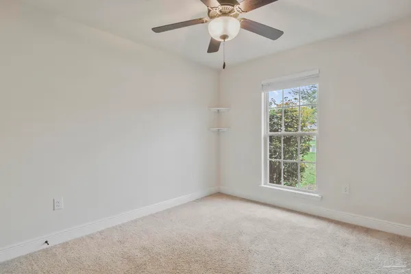 an empty room with a window and a fan