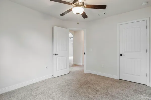 a view of an empty room and chandelier fan