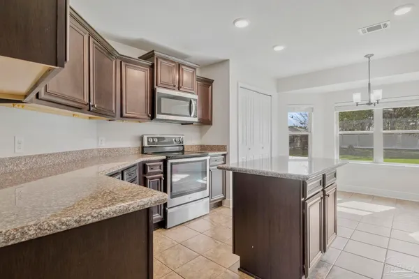 a kitchen with stainless steel appliances granite countertop a sink stove and microwave