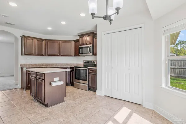 a kitchen with stainless steel appliances granite countertop a stove and a refrigerator with cabinets
