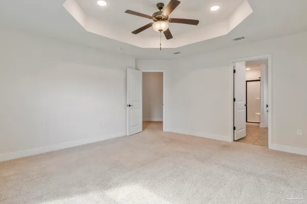an empty room with closet and a ceiling fan