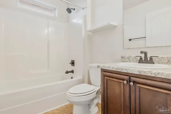 a bathroom with a granite countertop sink a toilet and bathtub