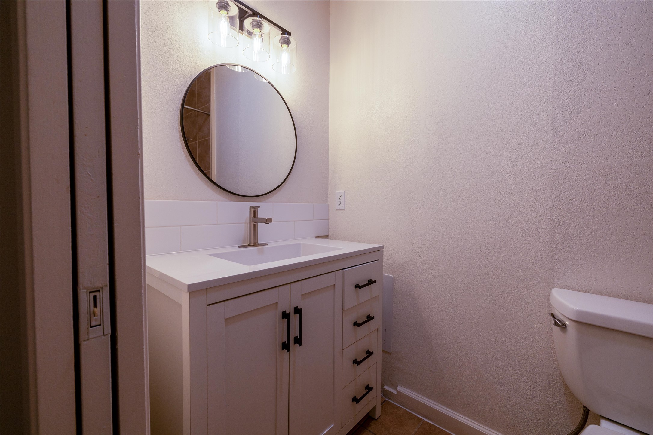 4304 Scottsdale Road Austin, TX 78721 - Photo 12 of 21 Half bath with vanity and a textured wall