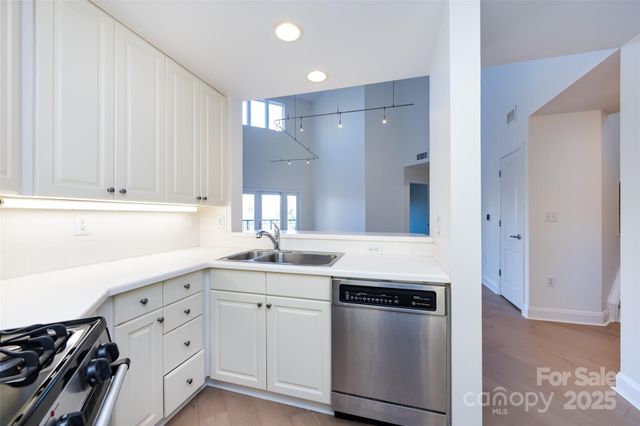 a kitchen with granite countertop white cabinets and white appliances