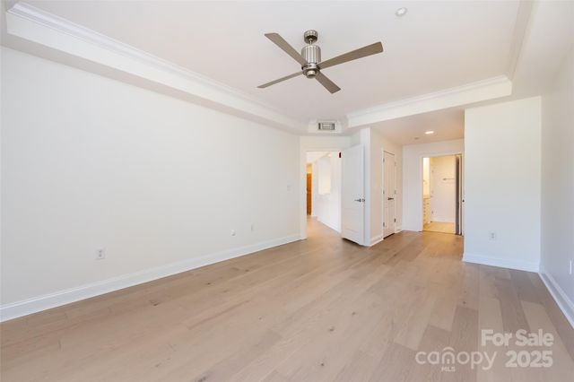 an empty room with ceiling fan and window